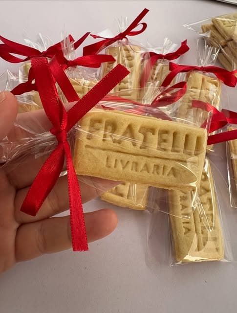 Bolachas personalizadas para a Fratelli Livraria em embalagens individuais com laços vermelhos